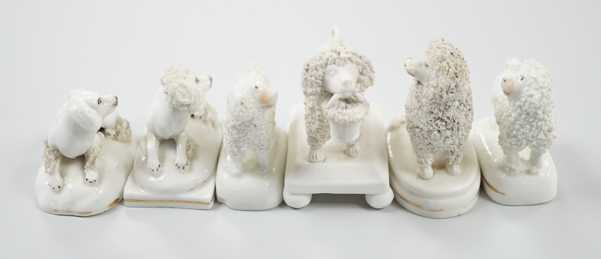 Five small Staffordshire models of poodles, together with a small poodle lying recumbent on an oval mounted base, possibly Davenport, c.1830-50, (6). Tallest 6.8cm., Provence: Dennis G. Rice collection, Cf. Dennis G.Rice
